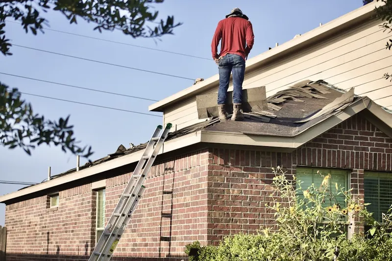 Professional roofer working on a residential roof in Friant